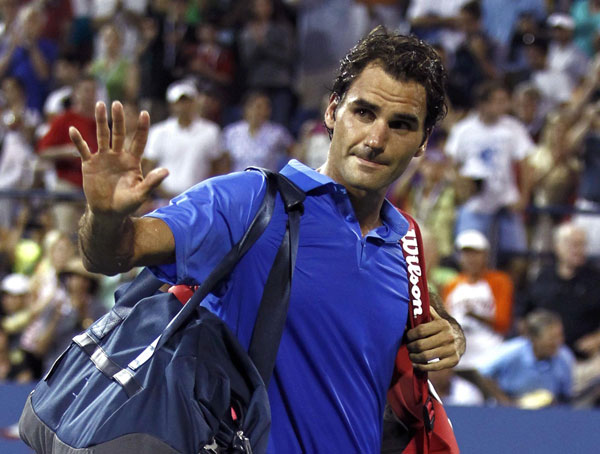 Roger Federer of Switzerland waves as he walks off the court after losing in three sets to Tommy Robredo of Spain at the U.S. Open tennis championships in New York September 2, 2013. Federer knocked out of US Open by Robredo