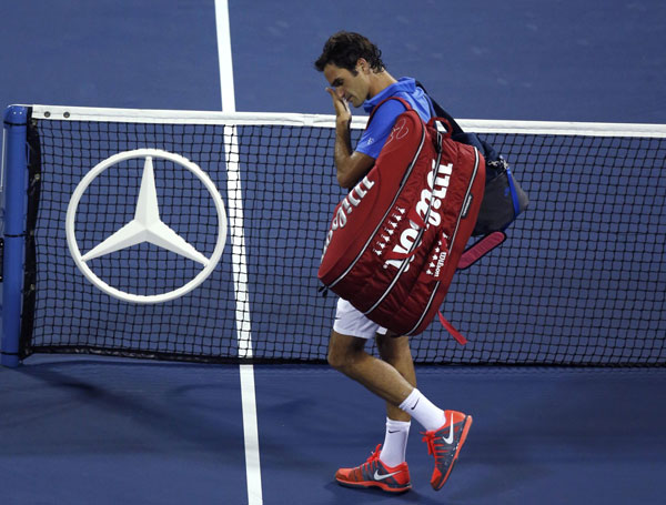 Roger Federer of Switzerland walks off the court after losing in three sets to Tommy Robredo of Spain at the U.S. Open tennis championships in New York September 2, 2013. Federer knocked out of US Open by Robredo