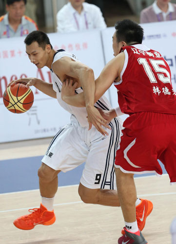 Yi Jianlian, left, of Guangdong goes for a basket against a Liaoning player during their men's basketball final against Liaoning at the National Games in Shenyang, Sept 12, 2013. Guangdong defended men's basketball title at Games