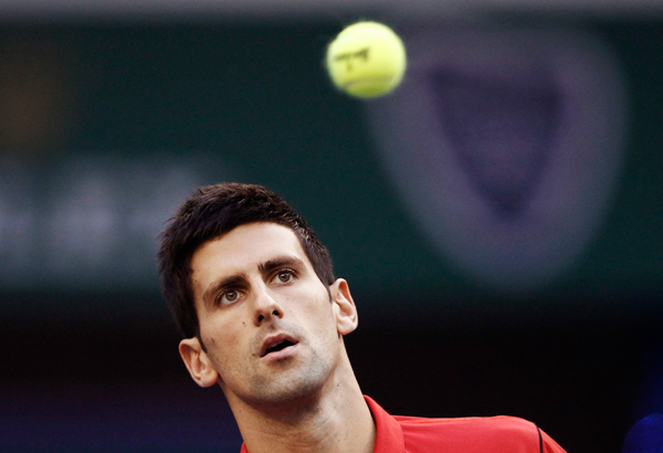 Novak Djokovic of Serbia looks at the ball as he hits a return during the men's singles final match against Juan Martin Del Potro of Argentina at the Shanghai Masters tennis tournament October 13, 2013. Djokovic retains Shanghai Masters title