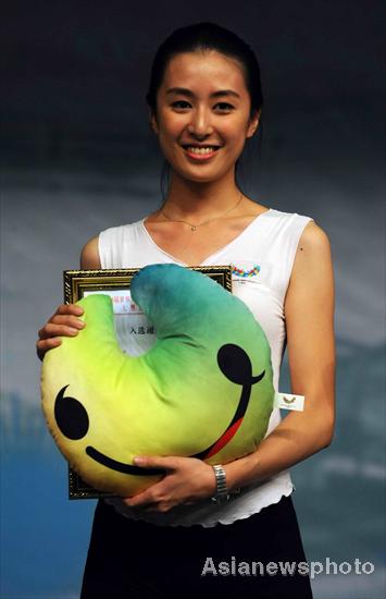 Wu Xiaobin, a Universiade volunteer from Shenzhen University, poses with a Universiade mascot in Shenzhen, South China's Guangdong province, April 30, 2011, when a competition to select 350 volunteers to carry medals at Universiade award ceremonies ended. Volunteers compete for a spot at Universiade
