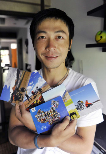 Zhou Ziqian shows postcards that display photos he took of people posing with UU, the mascot for the Shenzhen Summer Universiade, in Shenzhen, Guangdong province, on August 14, 2011. Zhou, a Shenzhen resident and a cycling enthusiast, spent 400 days biking around China, collecting 2,011 photos of people posing with UU and promoting the Universiade. Man's epic bike journey promotes Universiade