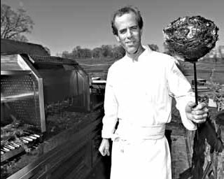 Chefs return wood to the cooking fire