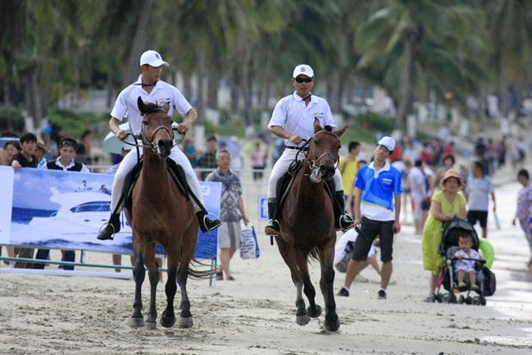 People try horseback riding during a beach equestrian festival in Sanya, March 28, 2013. Beach equestrian festival held in S China