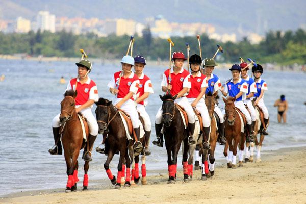 Polo players march along the beach on horseback, March 28, 2013. Beach equestrian festival held in S China