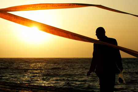 An Egyptian policeman investigates the area in the Red Sea resort of Dahab April 25, 2006. Bombers have struck again at a resort in Egypt's Sinai Peninsula, killing at least 23 people in three nearly simultaneous explosions in a market and restaurant area popular with foreign tourists.