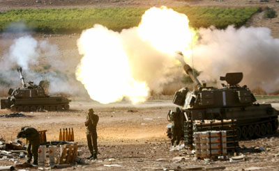 Israeli soldiers stand behind 155mm mobile artillery firing into southern Lebanon, from a position on the Israeli-Lebanese border August 6, 2006. Hizbollah killed 11 Israeli soldiers on Sunday in its deadliest rocket strike yet and Israeli bombs killed 18 Lebanese civilians as Lebanon rejected a draft U.N. resolution to end the 26-day-old war.