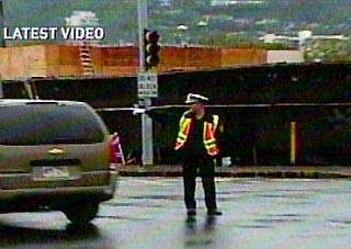 A police officer directs traffic at an intersection with darkened traffic lights in Honolulu in this October 15, 2006 video grab. A powerful earthquake and repeated aftershocks rattled Hawaii on Sunday, knocking out power and unnerving residents and vacationers but causing no injuries or extensive structural damage, agencies reported.