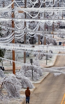 A pedestrian walks underneath ice-covered power lines near downtown McAlester, Okla., Tuesday, Jan. 16, 2007.