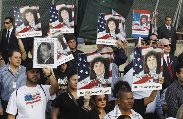 People hold up pictures remembering victims of the attacks during ceremonies marking the 10th anniversary of the 9/11 attacks on the World Trade Center, in New York, Sept 11, 2011. Mourning for 9/11 victims