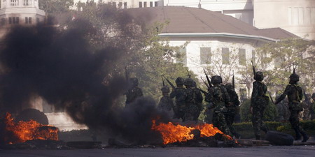 Thai troops surround protestors after 2 killed in clash