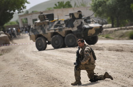 Afghan school continues as soldiers guard aside