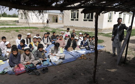 Afghan school continues as soldiers guard aside