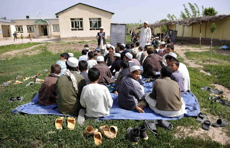 Afghan school continues as soldiers guard aside