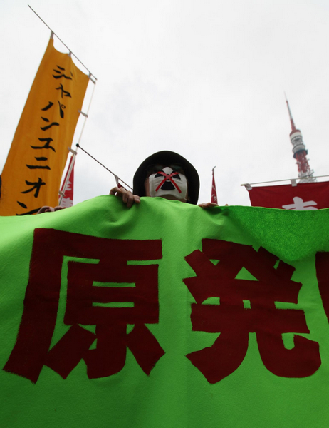 A protester holds a banner at an anti-nuclear rally during a memorial for the third month anniversary of the March 11 earthquake and tsunami, in Tokyo June 11, 2011. After 3 months, anti-nuke protests in Japan
