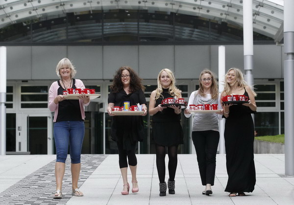 News of the World employees bring tea and coffee to reporters waiting outside News International headquartes in London July 9, 2011. UK's News of the World bids farewell to readers