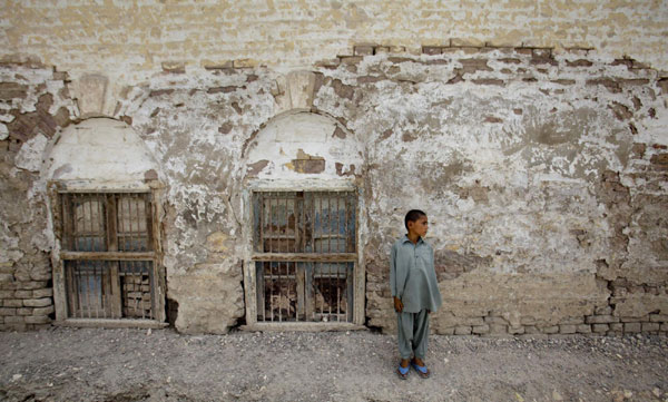 Ajeebullah, 8, displaced by heavy floods for almost a year, stands next to a wall with flood waters stain marks in Sultankot, some 51 km (31 miles) from Sukkur, located in Pakistan's Sindh province on July 11, 2011. Flood victims in Sukkur, Pakistan