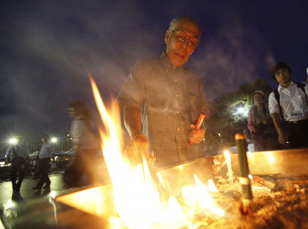 A man burns incense to pray for the victims of the atomic bombing by the US, in the Peace Memorial Park during the early morning in Hiroshima August 6, 2011, on the 66th anniversary of the world's first atomic bombing on the city. Japan PM brings nuclear-free vision to Hiroshima