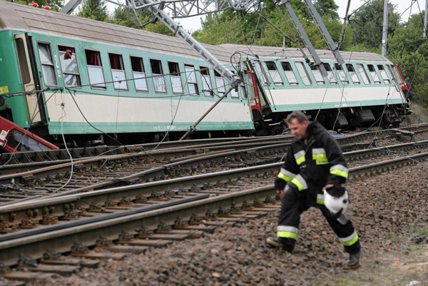An emergency services personnel inspects the wreckage of a passenger train that derailed near the village of Baby, in central Poland, Aug 12, 2011. Polish train derails, 4 people killed