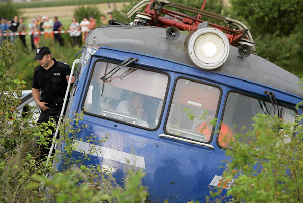 Emergency services personnel inspect the wreckage of a passenger train that derailed near the village of Baby, in central Poland Aug 12, 2011. Polish train derails, 4 people killed