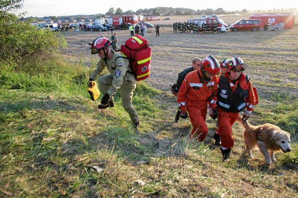 Members of emergency services personnel arrive with search dogs to inspect the wreckage of a passenger train that derailed near the village of Baby, in central Poland Aug 12, 2011. Polish train derails, 4 people killed