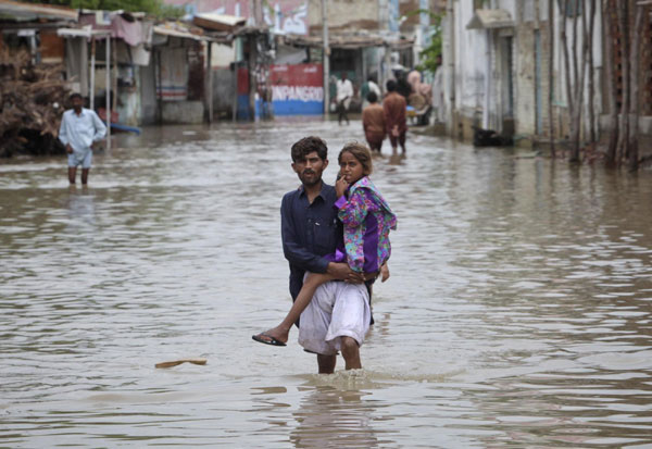 A man carries his sister as he escapes from the flood waters of Pangrio town in the Badin district of Pakistan's Sindh province Sept 14, 2011. 300,000 homeless due to flood in Pakistan