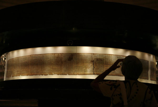 A visitor looks at a facsimile of the Isaiah Scroll, one of the Dead Sea Scrolls, displayed inside the Shrine of the Book at the Israel Museum in Jerusalem Sept 26, 2011. 2000-Year-Old Dead Sea Scrolls Go Online