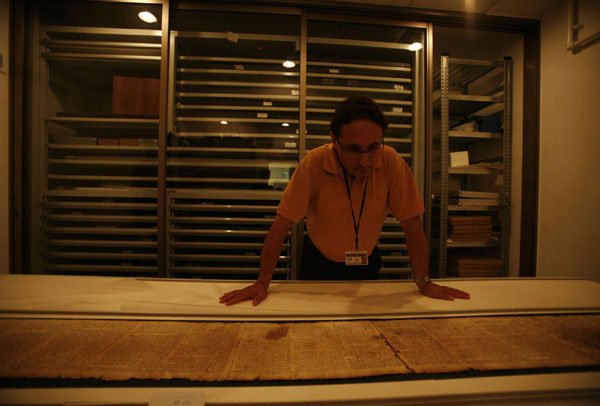 Adolfo Roitman, curator of the Dead sea Scrolls, looks at the original Isaiah Scroll, one of the Dead Sea Scrolls, inside a secured climate-controlled room in the Shrine of the Book at the Israel Museum in Jerusalem Sept 26, 2011. 2000-Year-Old Dead Sea Scrolls Go Online