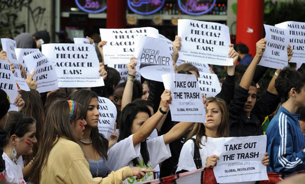 Students hold placards against Italian Prime Minister Silvio Berlusconi during a demonstration in Milan October 14, 2011. Berlusconi wins confidence vote but still weak