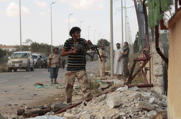 Anti-Gadhafi fighters return fire during clashes with pro-Gadhafi forces in Sirte October 19, 2011. Gadhafi killed as Libya's revolt claims hometown