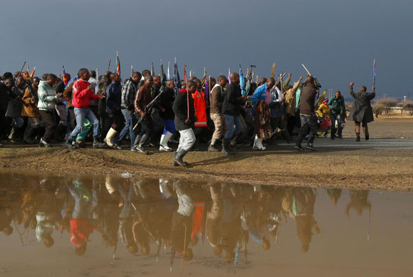 Striking mineworkers march S. African miners march outside Marikana mine