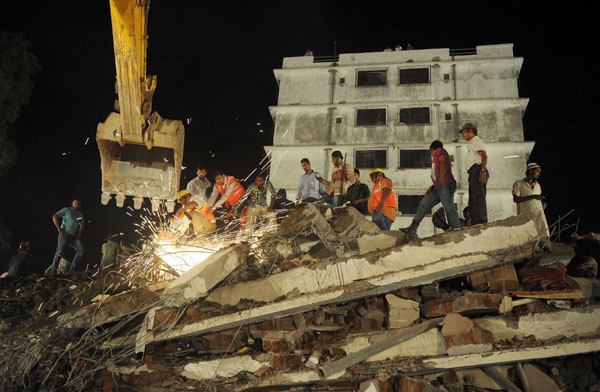 Indian rescue workers cut metal rods as they search for survivors in the debris of a collapsed building in Thane, on the outskirts of Mumbai, on Thursday. Punit Paranjpe / Agence France-Presse Building collapse in Mumbai suburb kills at least 42