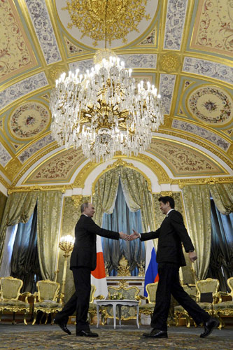 Russia's President Vladimir Putin (L) approaches to shake hands with Japan's Prime Minister Shinzo Abe during a meeting at the Kremlin in Moscow April 29, 2013. Russia, Japan try to bridge gaps on thorny issues