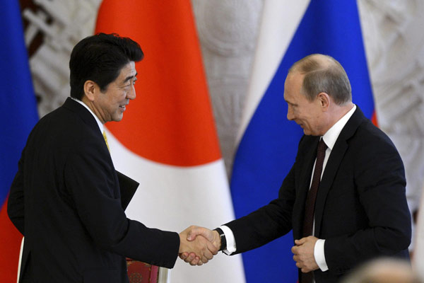 Russia's President Vladimir Putin (R) shakes hands with Japan's Prime Minister Shinzo Abe during a signing ceremony at the Kremlin in Moscow April 29, 2013. Russia, Japan try to bridge gaps on thorny issues