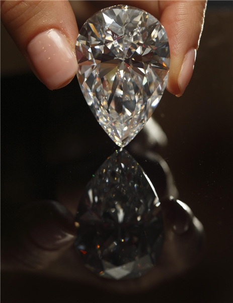 A Christie's member of staff displays a pear-shaped, D color, flawless diamond of 101.73 carats during an auction preview in Geneva, April 30, 2013. 101.73-carat diamond to be auctioned for over $20 million
