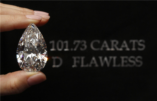 A Christie's member of staff displays a pear-shaped, D color, flawless diamond of 101.73 carats during an auction preview in Geneva, April 30, 2013. 101.73-carat diamond to be auctioned for over $20 million
