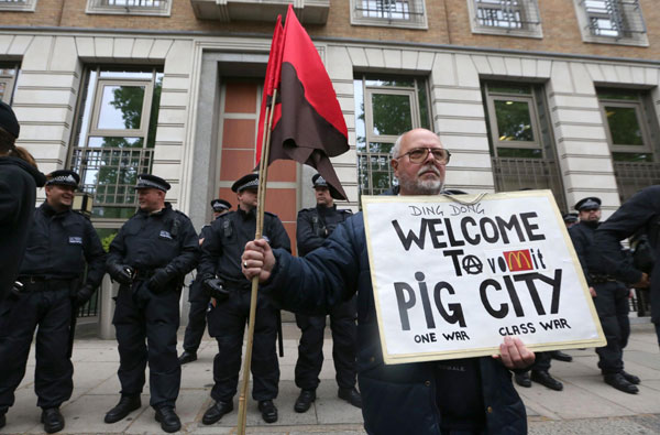 Police stand outside the BP headquarters during a protest against the upcoming G8 summit in London, June 11, 2013. Anti-G8 protests aim for Canary Wharf banking district