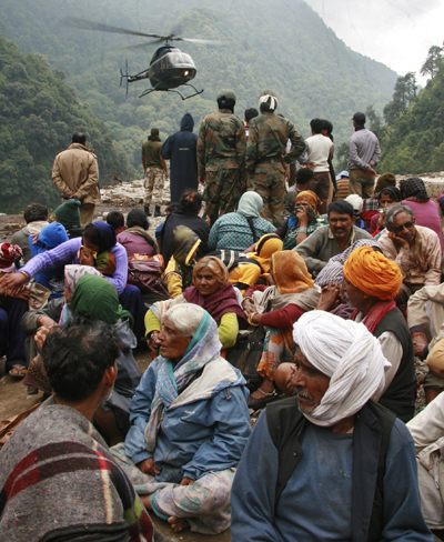 Stranded people wait for their turn to be rescued by a helicopter after heavy rains in the northern Indian state of Uttarakhand on June 23, 2013. Death toll in India floods could reach 8,000