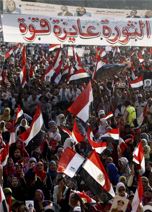 Protesters who are against deposed Egyptian President Mohamed Morsi hold Egypt flags and shout slogans at Tahrir square in Cairo, July 7, 2013. Huge crowds rally in Egypt, political talks stalled