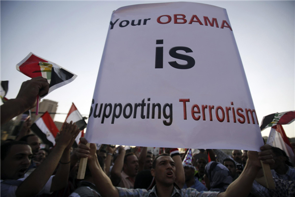 A protester who is against former Egyptian President Mohamed Morsi shouts slogans and holds a placard against US President Barack Obama during a protest at Tahrir square in Cairo, July 7, 2013. Huge crowds rally in Egypt, political talks stalled