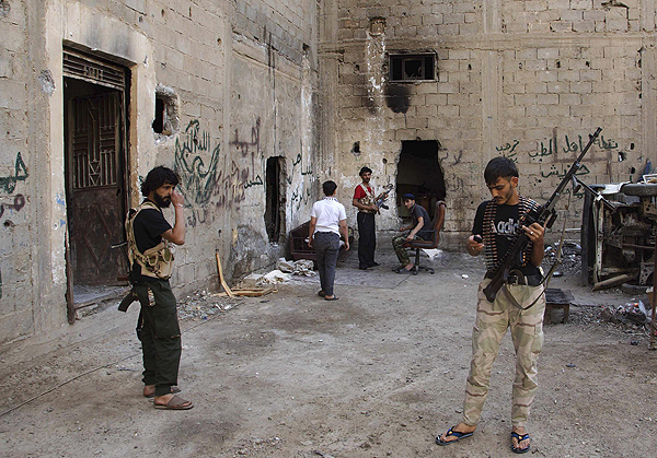 Free Syrian Army fighters carry their weapons as they prepare themselves prior to an offensive against forces loyal to Syria's President Bashar al-Assad in Deir al-Zor July 11, 2013. New front opens in Syria against al Qaida