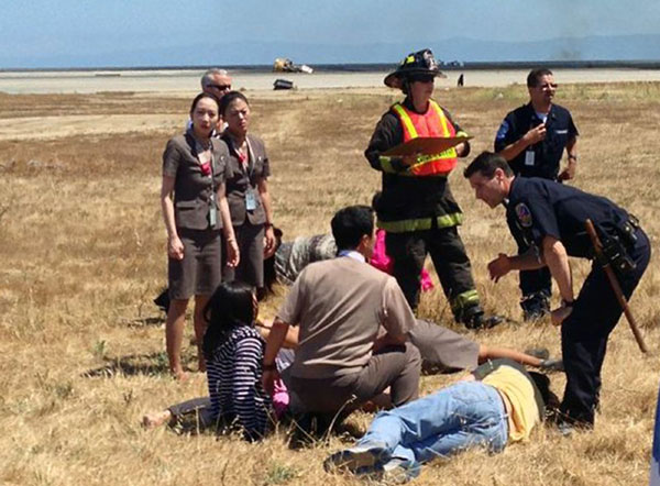 Asiana Airlines flight attendant Kim Ji-yeon (L) stands near a runway with rescued passengers after Flight 214 crash-landed at San Francisco International Airport in California, July 6, 2013 3rd Chinese girl dies of injuries in Asiana air crash
