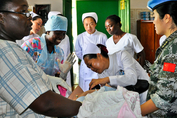 A Chinese doctor demonstrates childbirth procedures in Liberia on May 6. China has sent more than 20,000 medical personnel to 66 countries and regions over the past 50 years. Medical relief abroad will improve: health authority