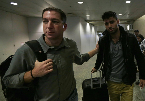 US journalist Glenn Greenwald (L) walks with his partner David Miranda in Rio de Janeiro's International Airport August 19, 2013. Snowden reporter to publish UK secrets