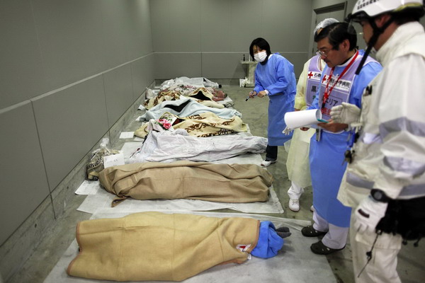 Japan begins to dig for dead amid nuke crisis